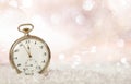 New Years eve countdown. Minutes to midnight on an old fashioned pocket watch, bokeh snowy background Royalty Free Stock Photo