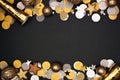 New Years Eve double border of confetti, decorations and noisemakers, top view over a black background