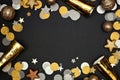 New Years Eve frame of confetti, decorations and noisemakers, top view on a black background Royalty Free Stock Photo