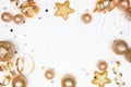 New Years Eve frame of confetti, streamers and gold decorations, top view over a white wood background