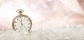 New Years eve party celebration. Minutes to midnight on an old fashioned pocket watch, bokeh snowy background, copy space Royalty Free Stock Photo