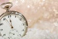 New Years eve party celebration. Minutes to midnight on an old watch, bokeh snowy background Royalty Free Stock Photo