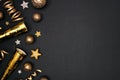 New Years Eve side border of glittery gold stars, streamers, decorations and noisemakers, top view over a black background Royalty Free Stock Photo