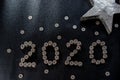 New Years 2020 graphic made from coins from Switzerland on a black shiny ground with silver star for concept