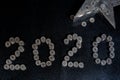 New Years 2020 graphic made from coins from Switzerland on a black shiny ground with silver star for concept Royalty Free Stock Photo