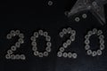 New Years 2020 graphic made from coins from Switzerland on a black shiny ground with silver star for concept