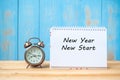 New years New Start text on notebook and retro alarm clock on table and copy space. Royalty Free Stock Photo