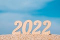 New Years numbers 2022 on a sandy beach against the sky. Creative Christmas card. Copy space. Selective focus Royalty Free Stock Photo