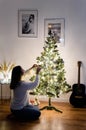 A woman hangs Christmas balls on the tree Royalty Free Stock Photo