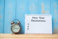 New years Resolutions text on notebook and retro alarm clock on table and copy space. Goals, Mission and New Start Royalty Free Stock Photo