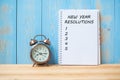 New years Resolutions text on notebook and retro alarm clock on table and copy space. Royalty Free Stock Photo