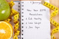 New years resolutions written in notebook and tape measure Royalty Free Stock Photo