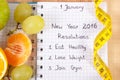 New years resolutions written in notebook and tape measure