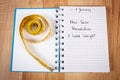 New years resolutions written in notebook and tape measure Royalty Free Stock Photo