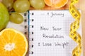 New years resolutions written in notebook and tape measure Royalty Free Stock Photo