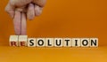 New years solution or resolution. Male hand flips wooden cubes and changes words `solution` to `resolution`. Beautiful orange
