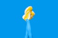 New Yellow female sneakers on long slender woman legs in blue tights isolated on blue background Royalty Free Stock Photo