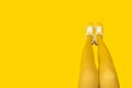 New Yellow female sneakers on long woman legs. Horizontal banner with copy space Royalty Free Stock Photo