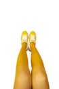 New Yellow female sneakers on long woman legs in yellow tights isolated on white background Royalty Free Stock Photo