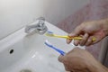 New yellow toothbrush and more old blue toothbrush in white basin Royalty Free Stock Photo