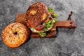 New York bagel with cream cheese, salad, cucumber, herbs, olives and salted red fish. Homemade sandwich salad on a cutting board. Royalty Free Stock Photo