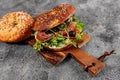 New York bagel with cream cheese, salad, cucumber, herbs, olives and salted red fish. Homemade sandwich salad on a cutting board. Royalty Free Stock Photo