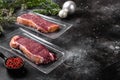 New York beef marbled meat vacuum packed steak in Christmas style, on black dark stone table background, with copy space for text Royalty Free Stock Photo