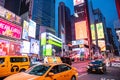 New York, Broadway streets at night. Illuminated high buildings, colorful neon lights, ads and people waiting Royalty Free Stock Photo