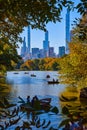 New York City Central Park pond with boats and large city buildings in background Royalty Free Stock Photo