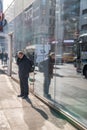 New York City, New York - December 6, 2018: Tourists and locals walk along Manhattan streets with buildings walls reflections Royalty Free Stock Photo