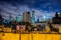 New York City downtown illuninated at night behind graffiti walls