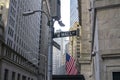 New York City, NY/USA - November 8 2020: Road sign of New York Wall street at the corner Broad street. American flag hanging from Royalty Free Stock Photo