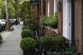 New York City, NY / USA - October 7 2020: Big gray, metal planters with foliage plants in front of brick wall house in West