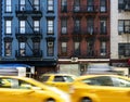 New York City street scene with yellow taxis driving past a block of old apartment buildings in the Upper East Side of Manhattan Royalty Free Stock Photo