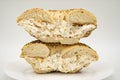 New York City Everything Bagel Cut in Half and Filled with Olive and Feta Cream Cheese on a White Plate Royalty Free Stock Photo