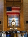 New York City, U.S - October 31, 2022 - The large gold clock under American flag inside of the Grand Central Terminal