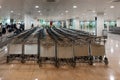 View of many empty airport luggage carts stacked in a row at the airport terminal hall with