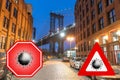 New York City, USA. Concept image with large red coronavirus warning sign in front of Brooklyn night skyline and Manhattan Bridge Royalty Free Stock Photo