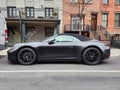 New York City, USA - February 10, 2024: Porsche 911 Carrera 4s cabriolet black car, side view