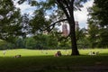 People enjoying a sunny day at the Central Park with the New York skyline in the background, in the city of New York, USA. Royalty Free Stock Photo