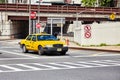 Yellow taxi cab stops at zebra crossing.