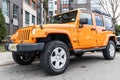 New York City, USA - March 31, 2024: 2012 Jeep Wrangler Unlimited Sahara yellow car parked outdoor, corner view