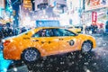 New York City, USA - March 18, 2017: People in yellow cab shot famous led advertising panels in Times Square during snow, one of Royalty Free Stock Photo