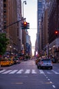 New York crowds and traffic at night. Empty road goes through Manhattan island near Time Square