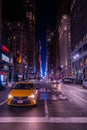 New York crowds and traffic at night. Empty road goes through Manhattan island near Time Square