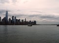 New York skyline and ferry cruising the Hudson river, skyline in the background at dusk