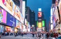 New York, Manhattan streets at night. Illuminated high buildings, colorful neon lights, ads and people walking Royalty Free Stock Photo