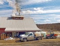 New York maple sugarhouse and smokestacks in Spring with white delivery truck