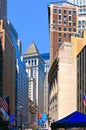 New York, Wall Street stock exchange with classic columns and old architecture, people walking and colorful flags of Royalty Free Stock Photo