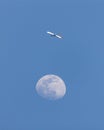 Delta airlines plane flying across the sky near an almost full moon. Royalty Free Stock Photo